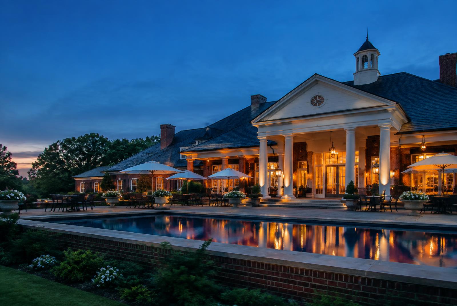 A private country club clubhouse at dusk, of the style associated with the Country Club of the Carolinas near Firethorne
